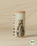 Verpackung eines Bio-Kräutertees "Küstenkräuter" mit Thymian und Lavendel, illustriert mit einer Person und einer Tasse.