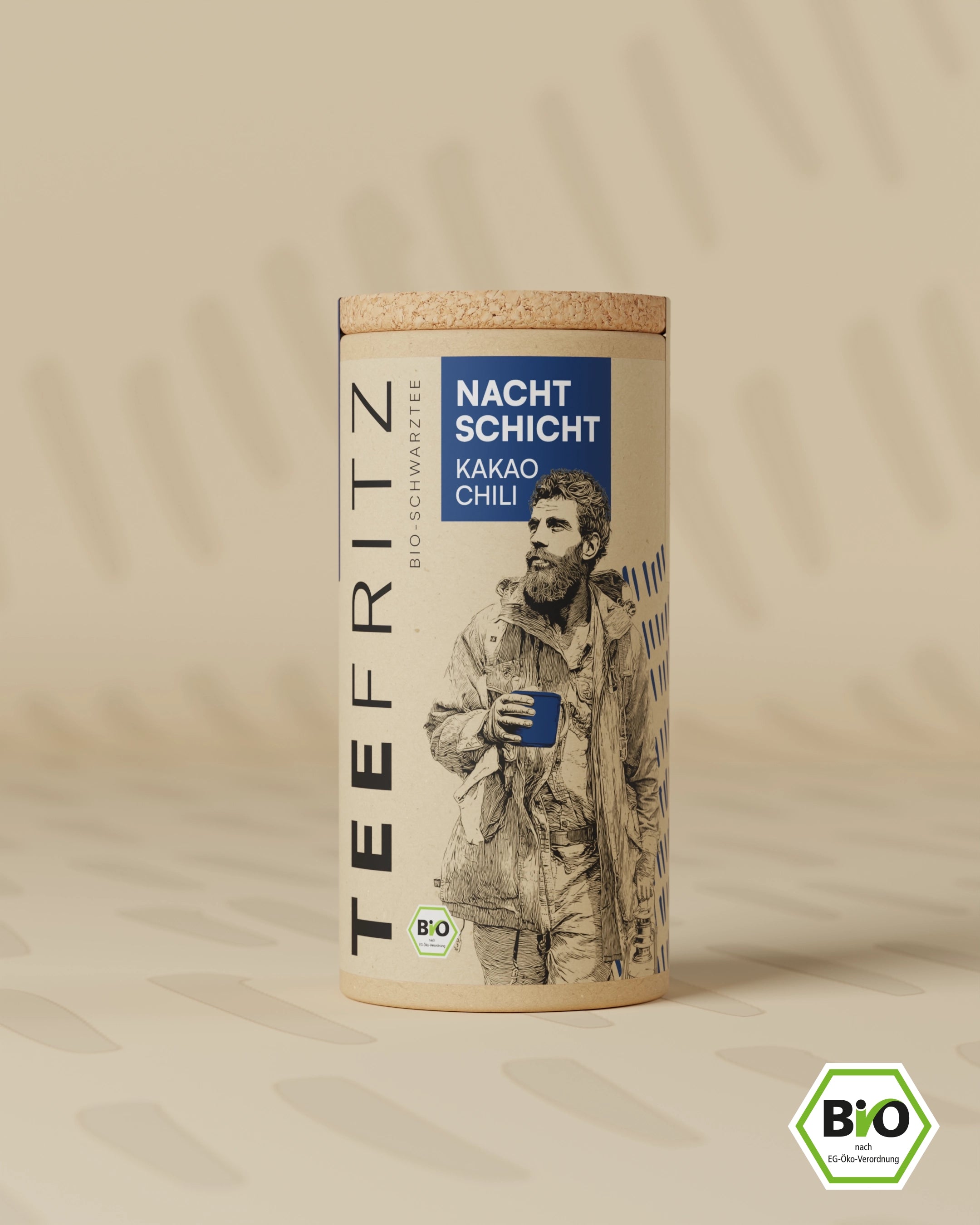 Runde Teedose mit der Aufschrift "Nachtschicht Kakao Chili" und einem gezeichneten Mann auf beigem Hintergrund.