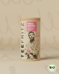 Braune Teeverpackung mit Aufschrift "Wohlgefühl Fenchel Rose" und einer gezeichneten Person, die eine Tasse hält.